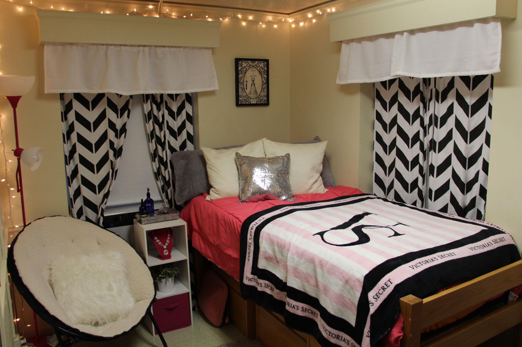 Example of a single mod dorm room, feautring a bed and curtains on two windows