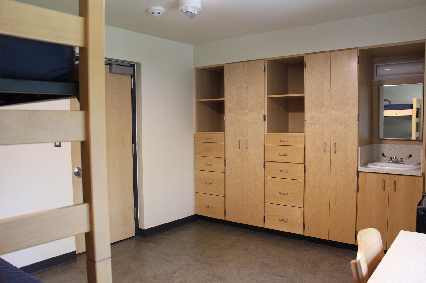 Example of a renovated double room on East Green, featuring lofted bunk beds, a desk, and built-in cabinets for storage