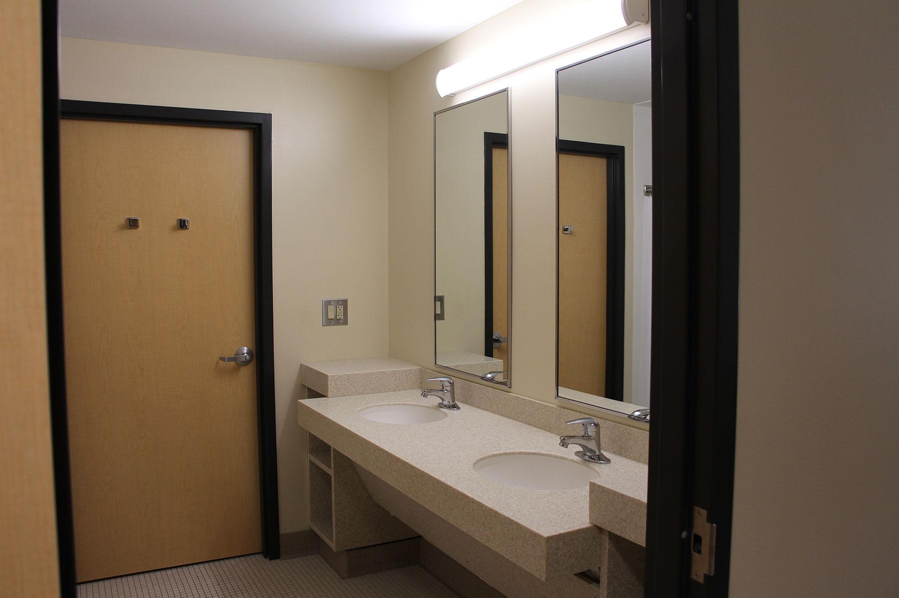 Example of a suite style dorm room's bathroom, featuring a double sink and mirrors