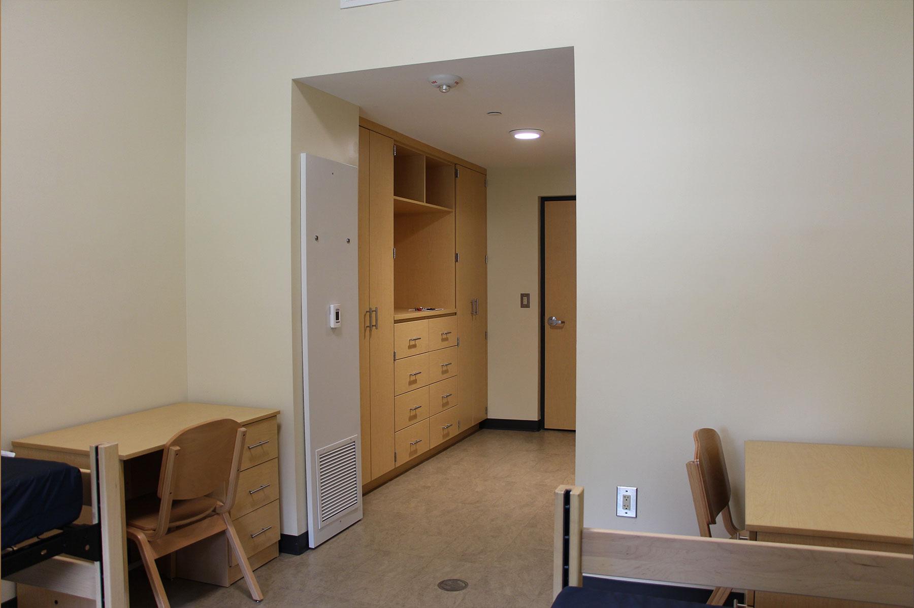 Example of a suite style double dorm room on South Green, featuring two beds and desks, and built-in storage