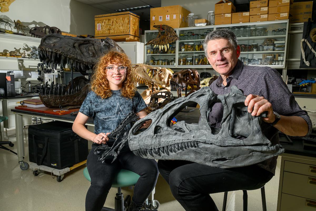 Larry Witmer poses with dinosaur bones and a student in his research lab