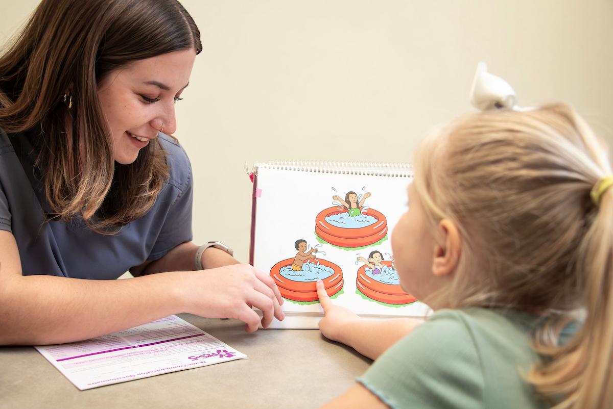 A Hearing Speech and Language college student works with a child in a clinical setting