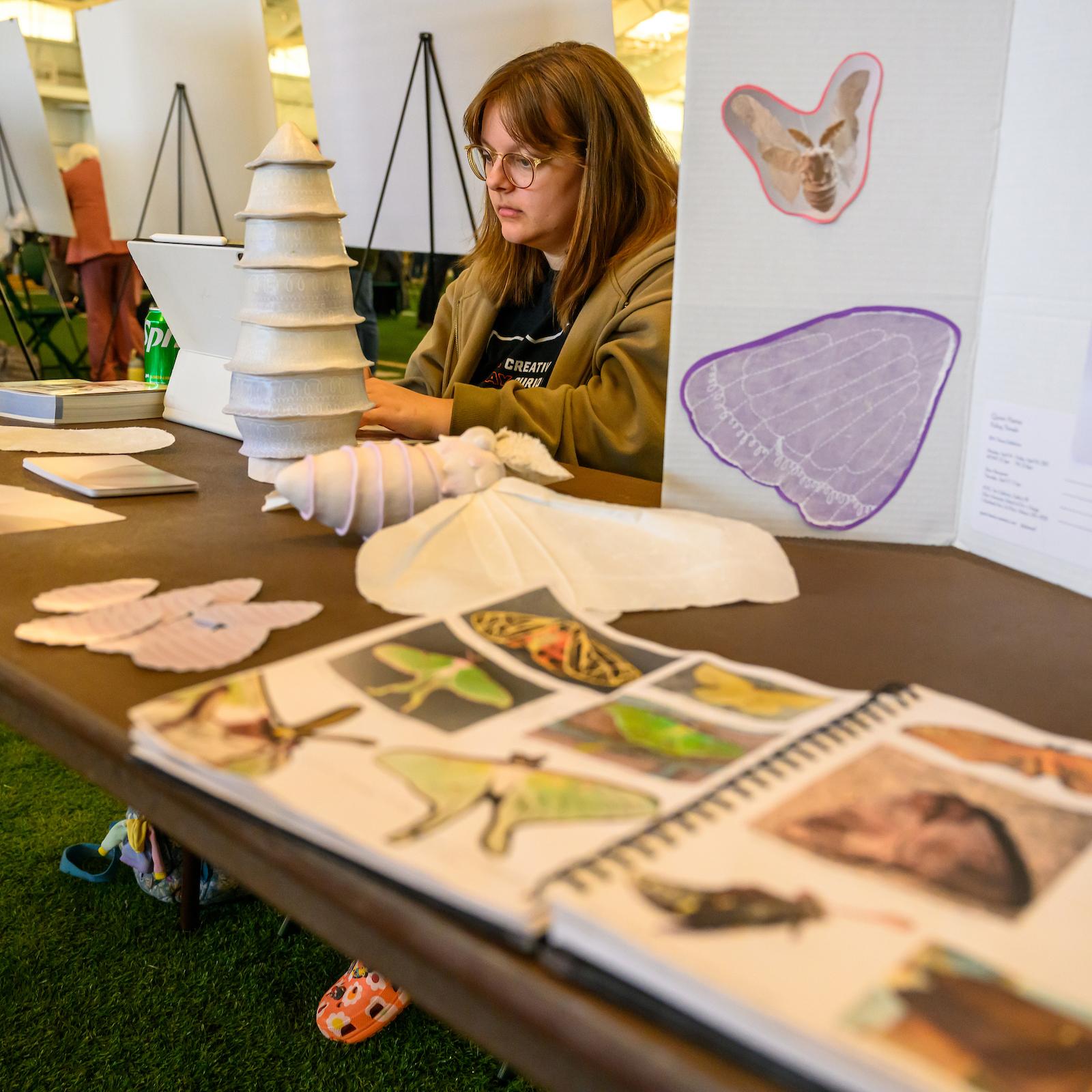 student displaying sculptures and found imagery