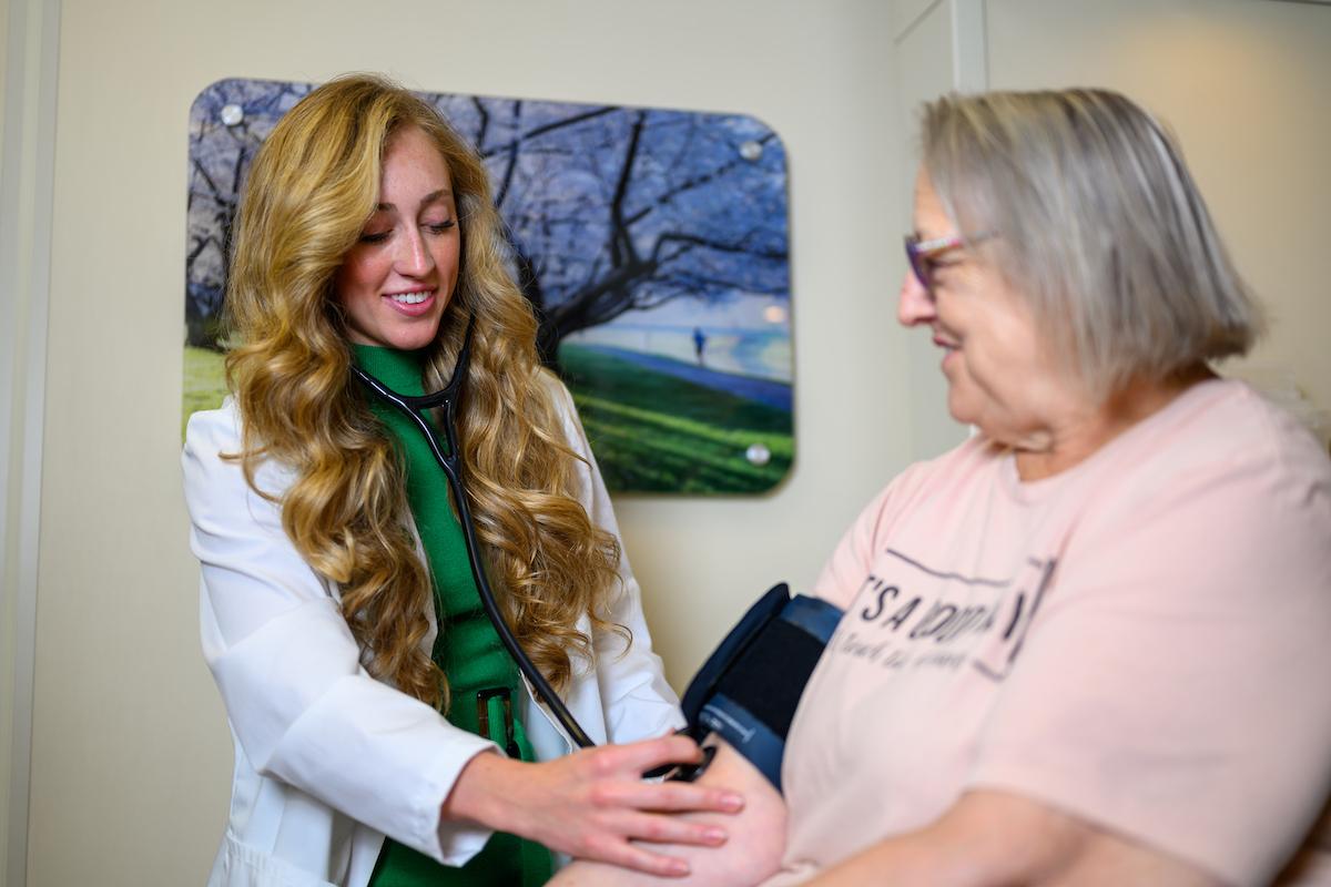 Nursing student performs a medical exam on a patient