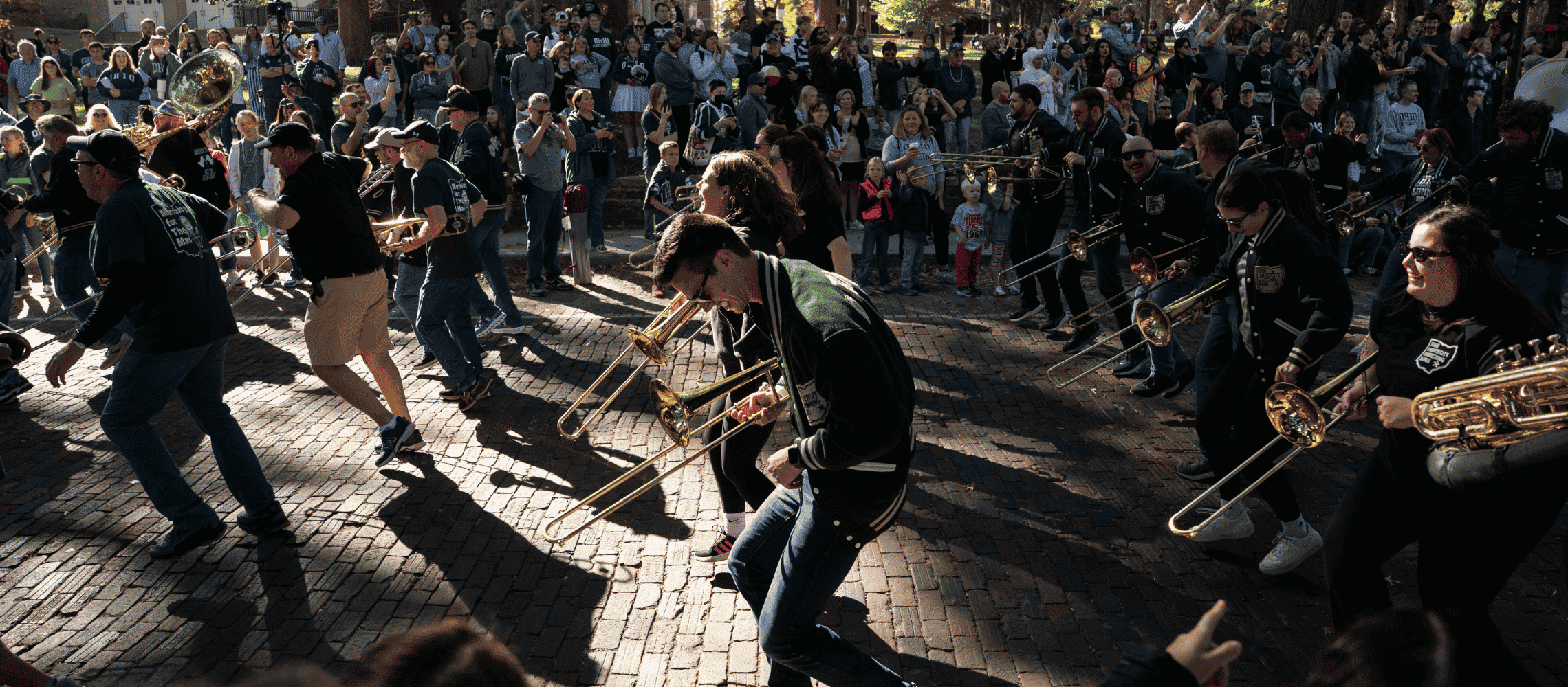 Alumni Band performing in Homecoming parade for a crowd of people
