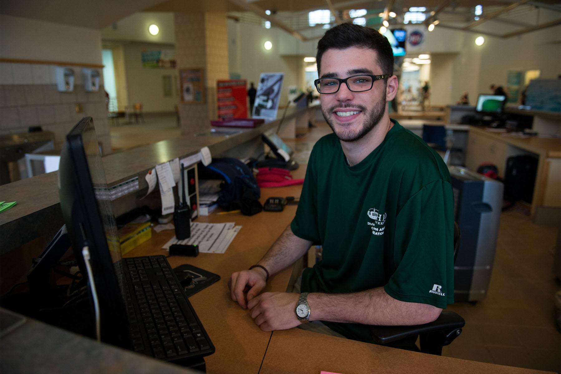 student employee at reception desk in ping center