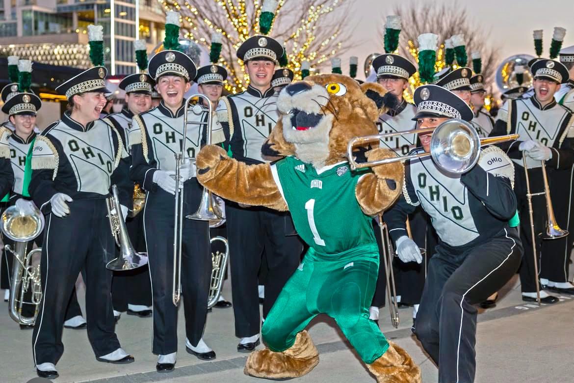 Rufus the Bobcat, OHIO's mascot, does a silly dance in front of the Marching 110.