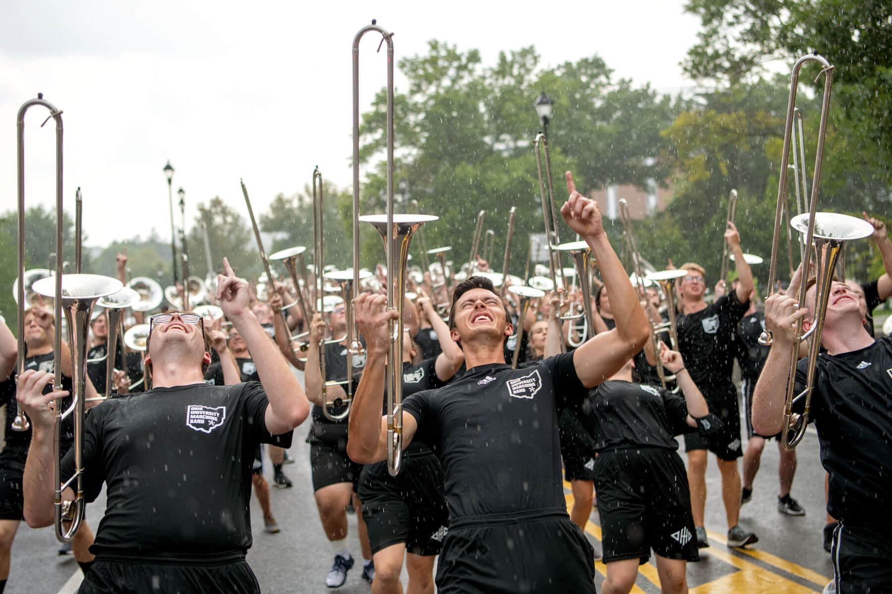 Members of the Marching 110 march in the rain during first year convocation