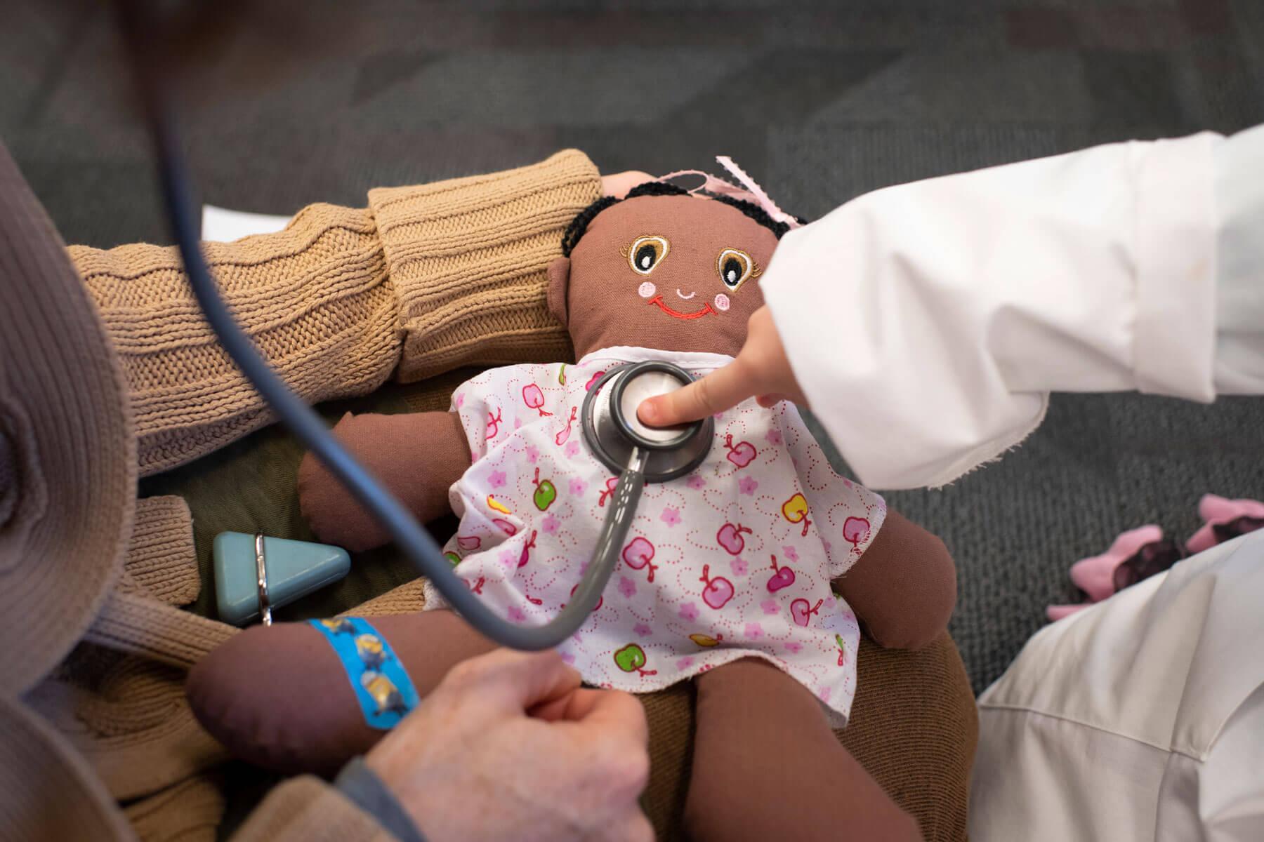 A child uses a stethoscope as first and second year med students associated with the Pediatrics Club host "Doctor for a Day" at Nelsonville Public Library