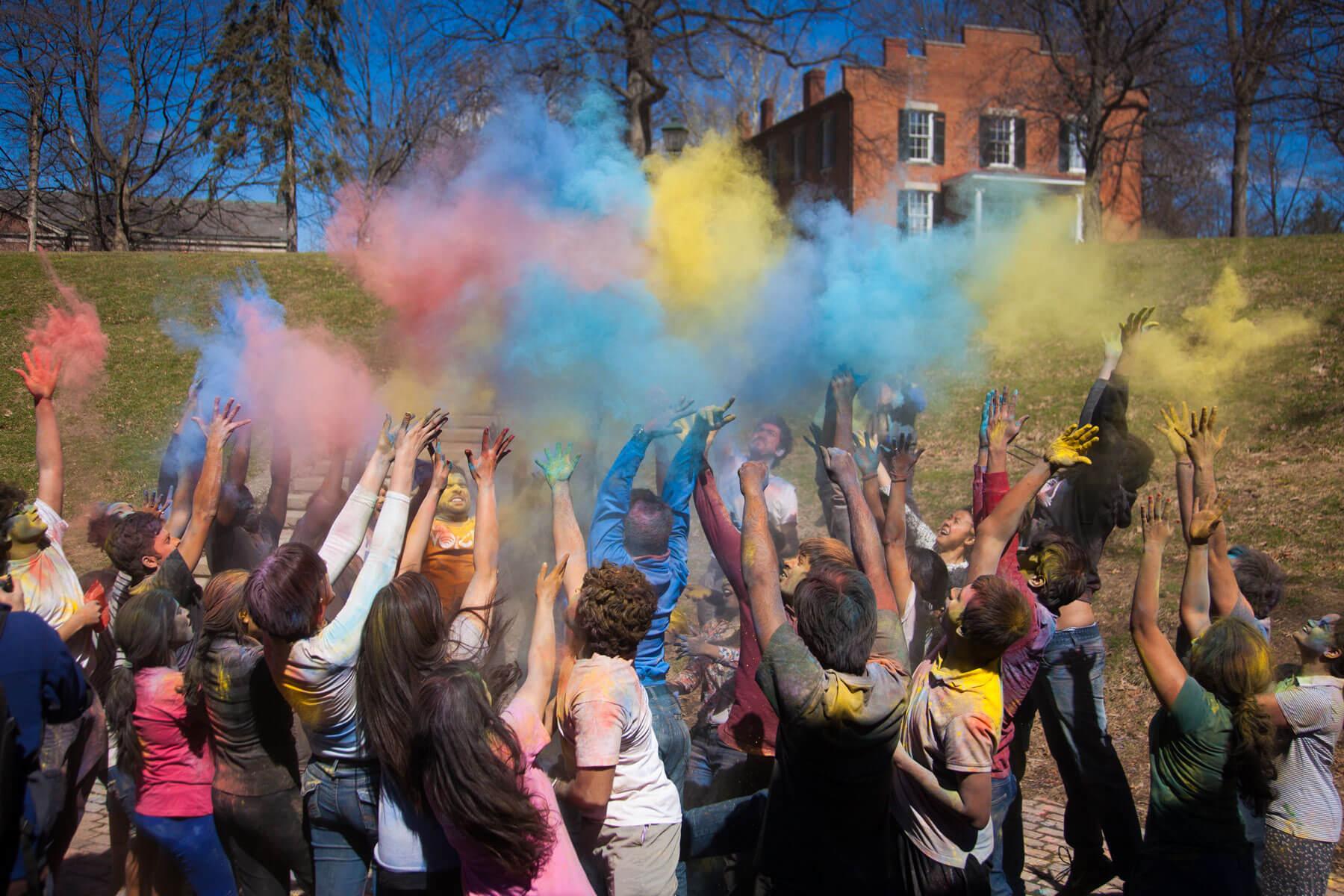 Holi celebration with a group of people throwing colored powder into the air