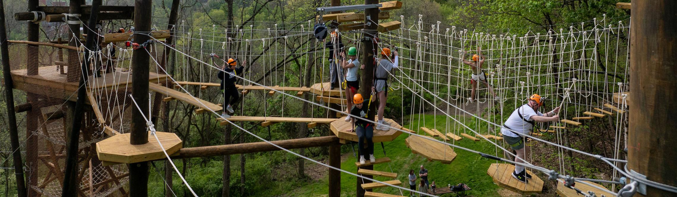 a team tries to navigate the elements in the odyssey course with ropes and obstacles
