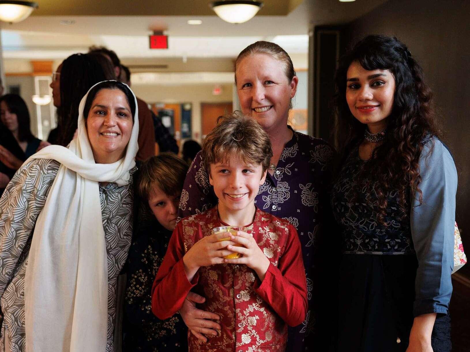 Three members of Friends of India pose for a picture, with two kids wearing traditional Indian clothing