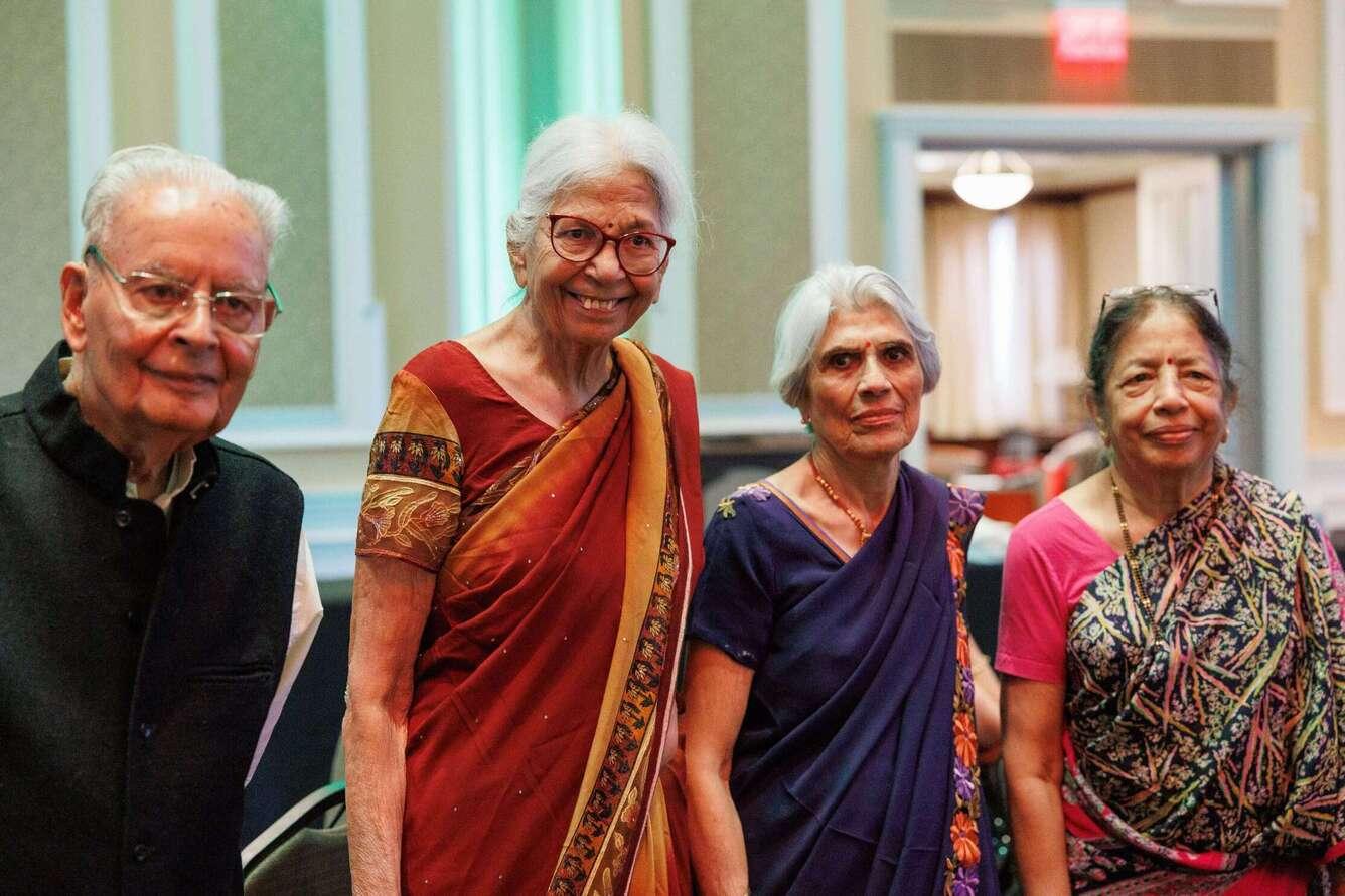 Dr. Raj and Dr. Sushila stand side by side with two other FOI members to their right