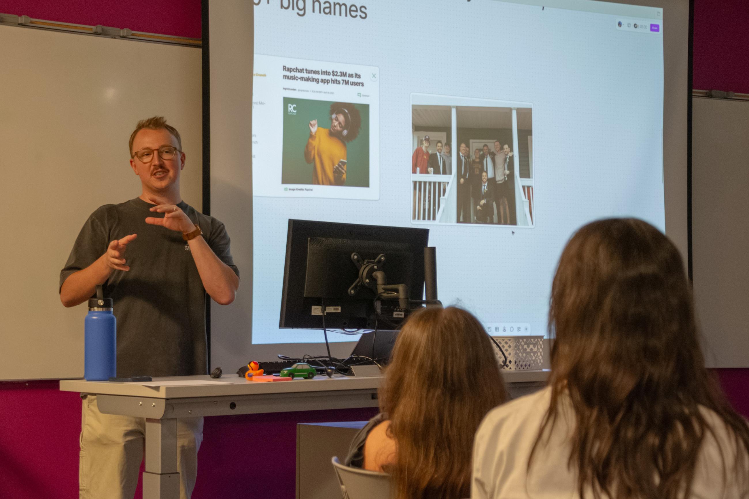 EIR Seth Miller speaking to students with a PowerPoint in the background