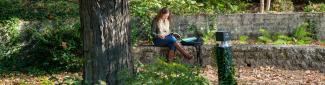 A student reads in the green space outside of Alden Library 4th floor