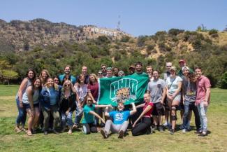 Ohio University students pose with an OHIO flag in front of the Hollywood sign