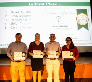 Four students stand next to each other holding first place certificates for the Eco Impact Challenge