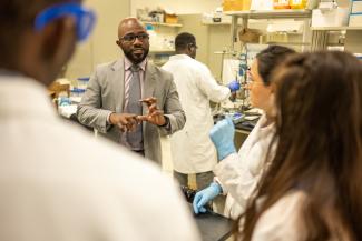 Professor Damilola Daramola speaks with students in his research lab