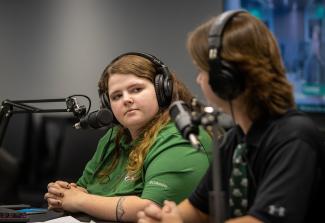 Two students speak into a microphone during an Ohio University Esports broadcast