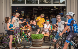 Photo taken outside of Little Fish, featuring cyclists and customers