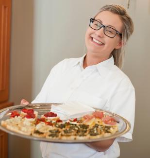 server holding platter of food at an event