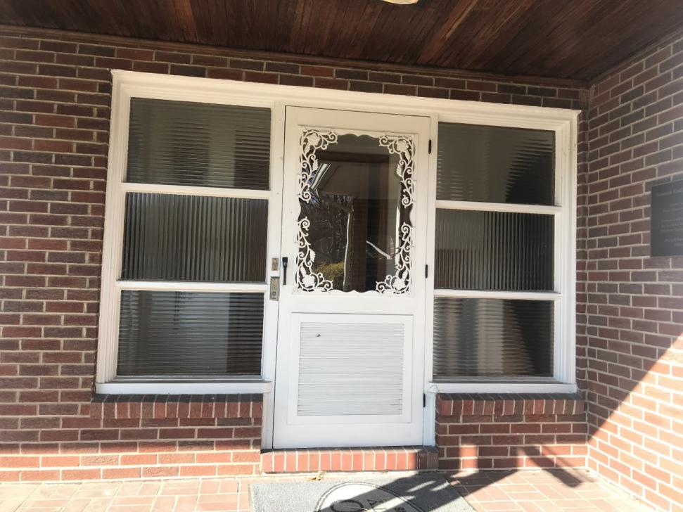 Front door: a decorative storm door with semi-transparent windows on left and right