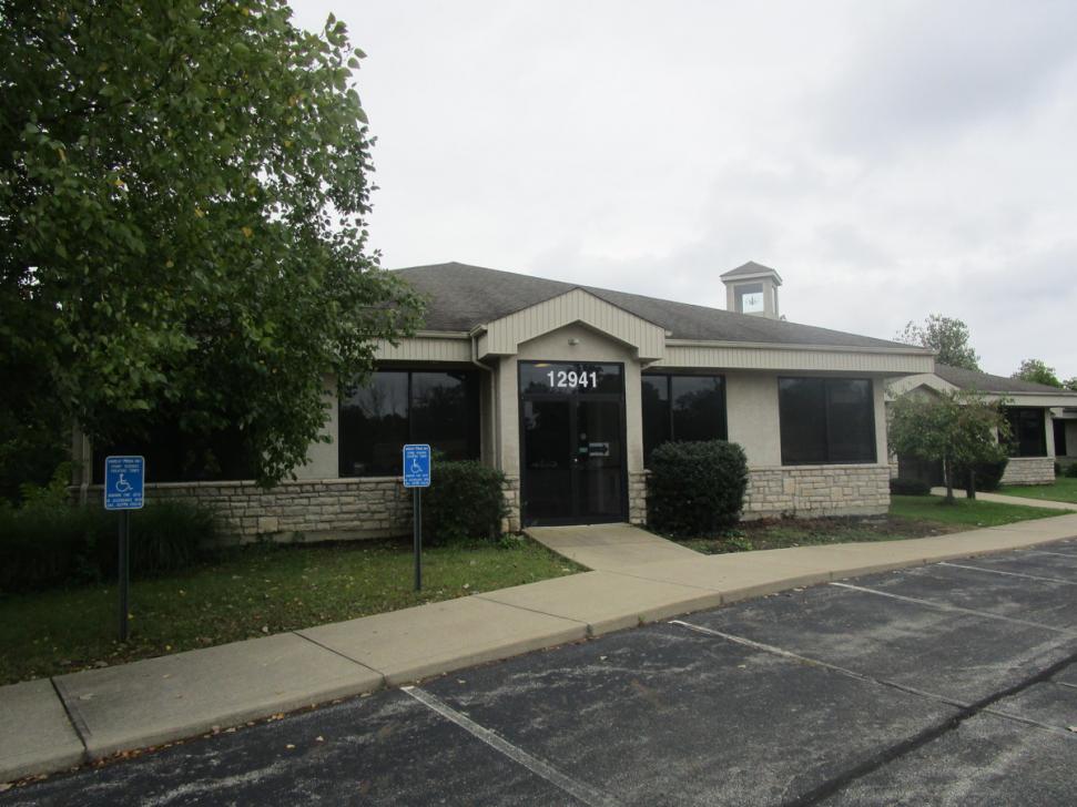 1-story commercial building with address 12941 on the door, beige concrete or stucco walls and stone or faux-stone trim, with concrete sidewalk alonsgside asphalt parking lot