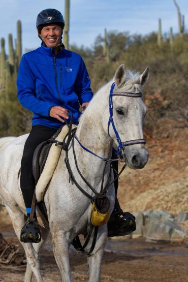 Lucian Spataro smiles while riding a horse.