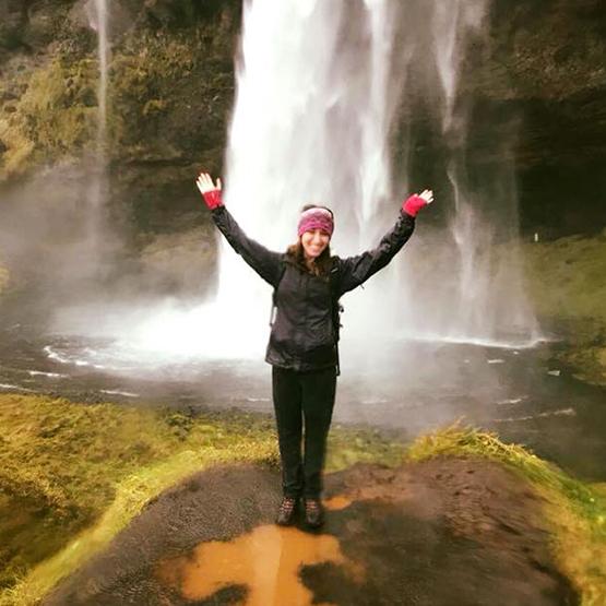 Ellie Kowler poses in front of a waterfall