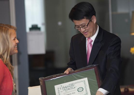A professor accepts a framed certificate for the University Professor award