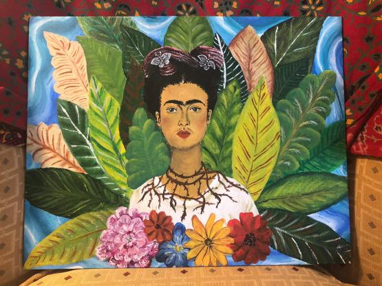 An acrylic rendition of Frida’s portrait ”Self,” featuring Frida Kahlo in the middle of a horizontal canvas from the chest up. Frida, as in the “Self” portrait, wears her hair up in braids, with a crown of red ribbons and silver butterflies atop her head. Her expression looks directly at the audience, and she wears a necklace of thorns that slightly pierce her neck, leaving small trails of blood. She wears a white blouse with a wide neckline, which is cut off at the chest area by a variety of large flowers.