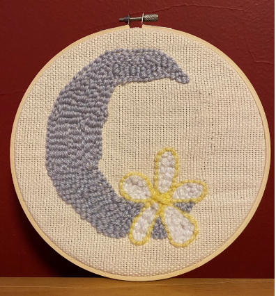 A grey crescent moon shape with a yellow outlined, white flower covering the bottom point. 