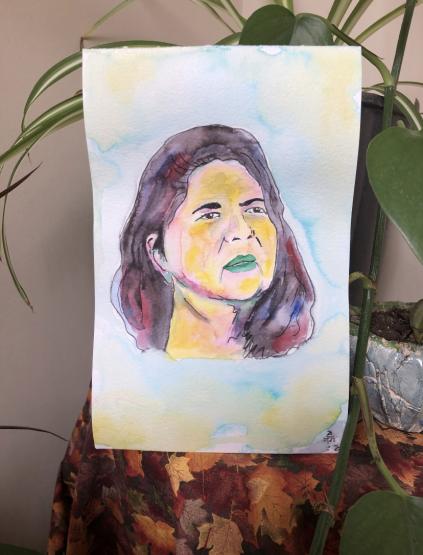 A portrait of Chief Wilma Mankiller’s face done in watercolors over a blue, teal, and yellow background. Wilma is featured with her hair down, looking towards the upper left-hand corner of the vertical image, with her facial features decorated in greens, blues, yellows, purples, and pinks. Her hair is a blend of blues, black, and red colors.