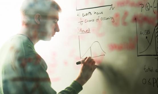 A student working out math problems on a whiteboard
