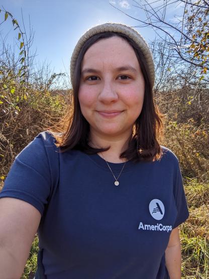 Photo of Emily Feist in blue Americorps T-Shirt on Ora Anderson Trail