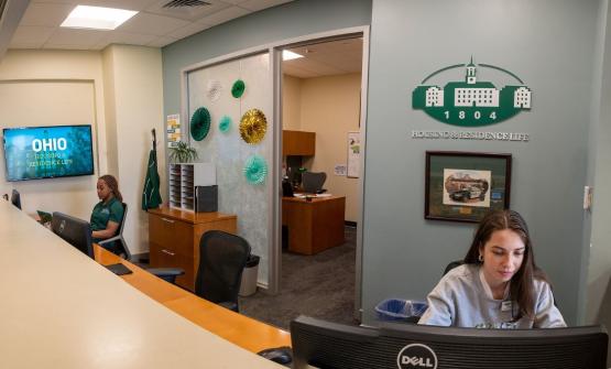 photo of student staff working the housing and residence life front desk