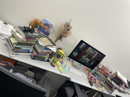 A photo of a cluttered desk with an iMac on it