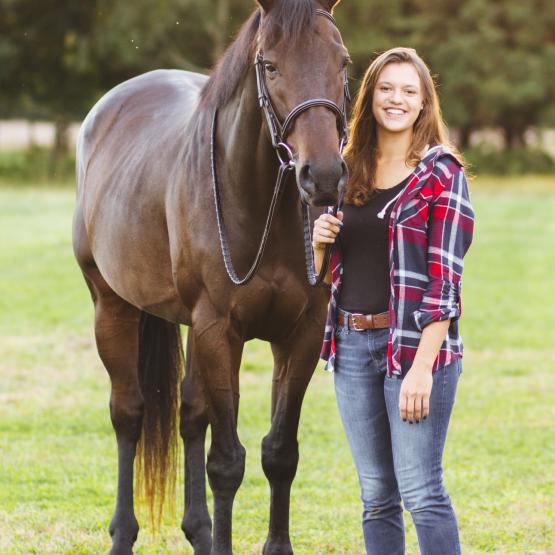 A equine studies student stands with a horse
