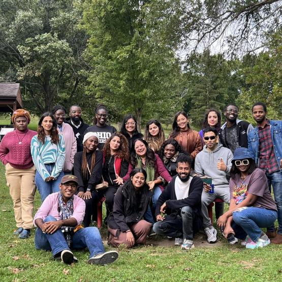 A group of Communication and Development Studies students pose, smiling, in a park