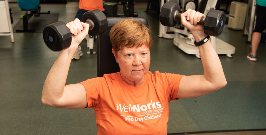 Member lifting weights in fitness center