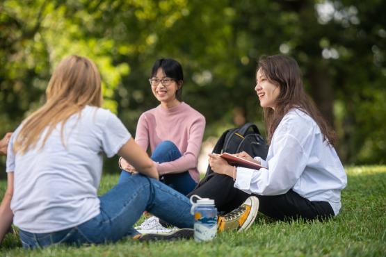 Three international students talking on College Green