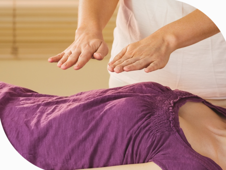 Reiki Master with hands placed several inches above client