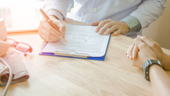 doctor and patient reviewing document on a clipboard