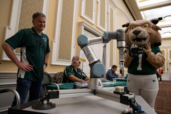 Ohio University's mascot looks at a robot