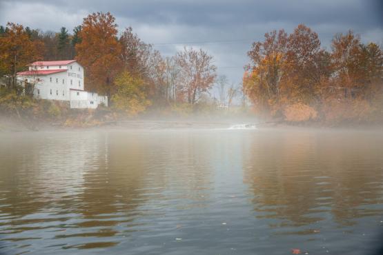 A view of White's Mill overlooking the Hocking River with fog.