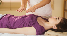 Reiki Master with hands placed several inches above client