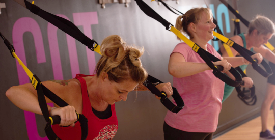Employees in a group fitness TRX class.