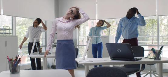 Group of people stretching at their desks