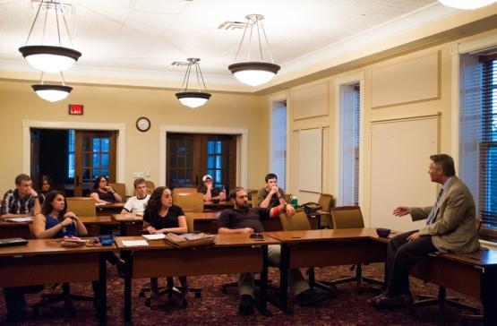 professor speaking with students in a classroom