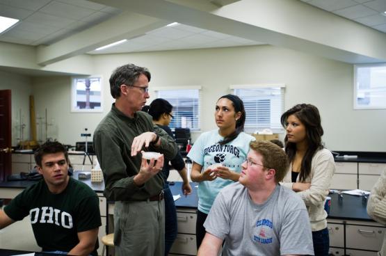 professor speaking with 4 students in a classroom